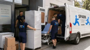 Pracownicy ładują kartony i wyposażenie do samochodu Spark Przeprowadzki.